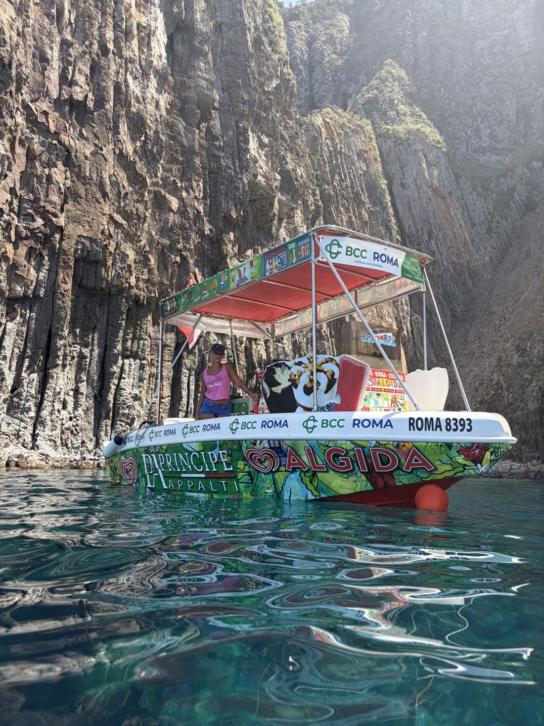 Un Barchino dei Gelati sotto le scogliere di Ponza, sull'acqua trasparente